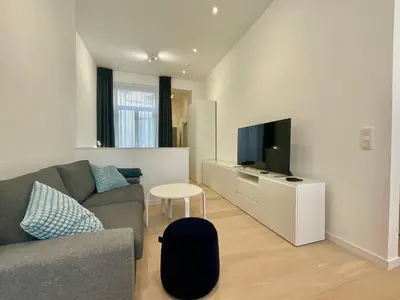 a living room with a couch and a flat screen tv at Chapeliers in Brussels