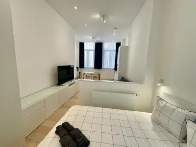a large white room with a white tiled floor at Chapeliers in Brussels
