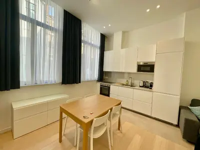 a kitchen with a wooden table and a dining room at Chapeliers in Brussels