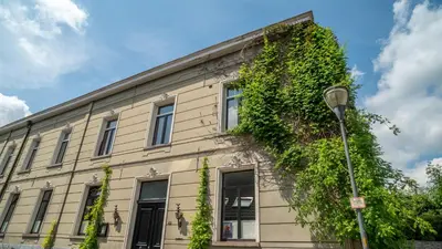 a building with ivy growing on the side of it at De Visitatie Rupelmonde in Rupelmonde
