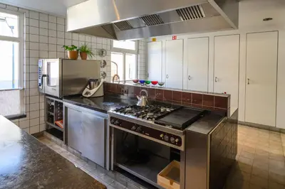 a kitchen with a stainless steel stove and a refrigerator at De Visitatie Rupelmonde in Rupelmonde