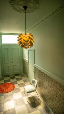 a room with a chair and a chandelier at De Visitatie Rupelmonde in Rupelmonde