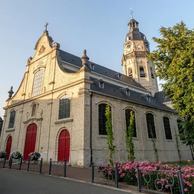 a church with a tower and a red door at De Visitatie Rupelmonde in Rupelmonde