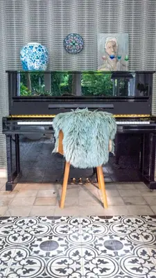 a chair with a blanket sitting in front of a piano at De Visitatie Rupelmonde in Rupelmonde