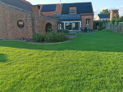 a house with solar panels on the roof at Cor-U in Dessel