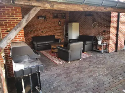 a patio with couches and a grill in a brick wall at Cor-U in Dessel