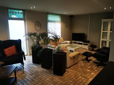 a living room with couches and plants in it at Cor-U in Dessel