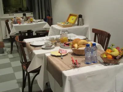 a table with two tables with white table cloths and food at Hotel Muske Pitter in Mechelen