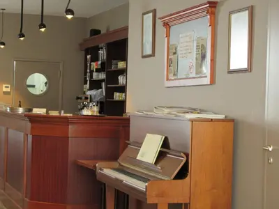 a cash register with a piano in a salon at Hotel Muske Pitter in Mechelen