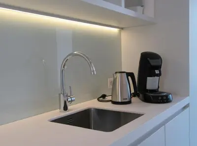 a kitchen counter with a sink and a coffee maker at Hotel Muske Pitter in Mechelen