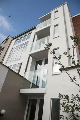 a white building with glass windows on the side of it at Hotel Muske Pitter in Mechelen
