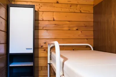 a bedroom with a bed and a wooden wall at Camping Floreal Kempen in Kasterlee