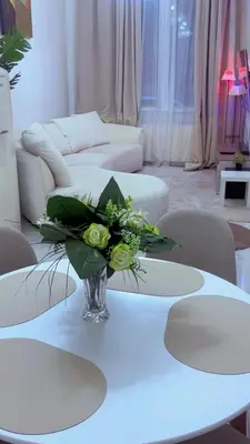 a white living room with a vase of flowers on a table at The Play Park Flat in Antwerp