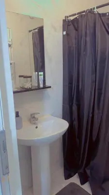 a bathroom with a sink and a black shower curtain at The Play Park Flat in Antwerp