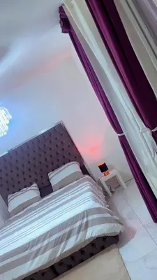 a bedroom with a large bed with purple curtains at The Play Park Flat in Antwerp