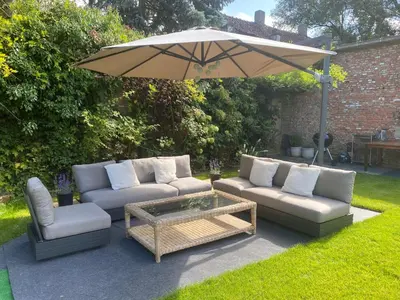 a patio with two couches and an umbrella at Huis krekelhof in Antwerp