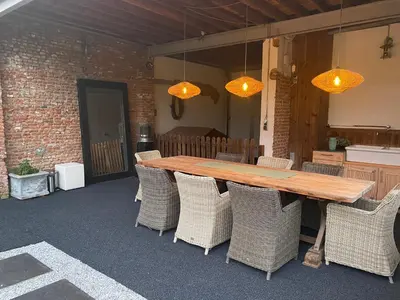 a wooden table with wicker chairs on a patio at Huis krekelhof in Antwerp