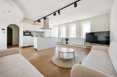 a living room with two couches and a table at Rooftop appartement in Sint-Niklaas