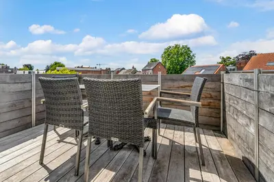 two chairs and a table on a balcony at Rooftop appartement in Sint-Niklaas