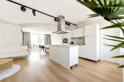 a kitchen and living room with white cabinets at Rooftop appartement in Sint-Niklaas