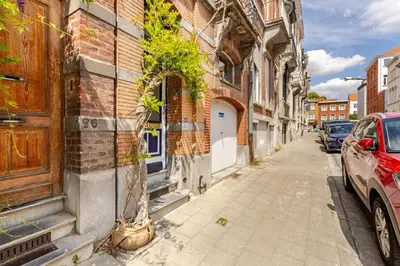 a street with a car parked next to a building at Maison du Cinquantenaire - The Residential in Brussels