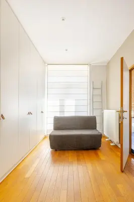 a bedroom with a bed on a wooden floor at Maison du Cinquantenaire - The Residential in Brussels