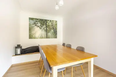 a dining room with a wooden table and chairs at Maison du Cinquantenaire - The Residential in Brussels