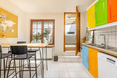 a kitchen with colorful cabinets and a table with stools at Maison du Cinquantenaire - The Residential in Brussels