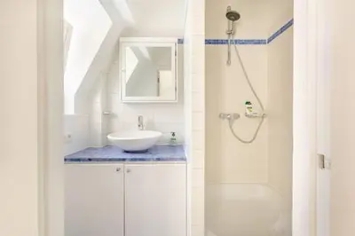 a white bathroom with a sink and a shower at Maison du Cinquantenaire - The Jubilee Loft in Brussels