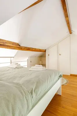 a white bedroom with a large bed with white cabinets at Maison du Cinquantenaire - The Jubilee Loft in Brussels