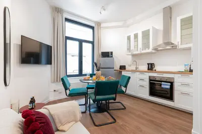 a kitchen and living room with a table and chairs at Chez Lilou et Babette 4 appartements 2 chambres in Brussels