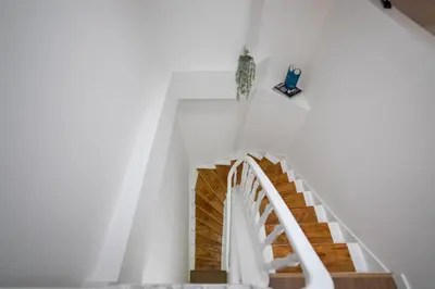 a staircase in a house with white walls and wooden floors at Chez Lilou et Babette 4 appartements 2 chambres in Brussels