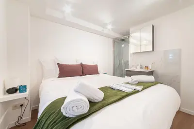 a bedroom with a white bed with towels on it at Chez Lilou et Babette 4 appartements 2 chambres in Brussels