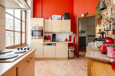 a kitchen with wooden cabinets and red walls at Luxury home at Grand Place & Manneken Pis in Brussels