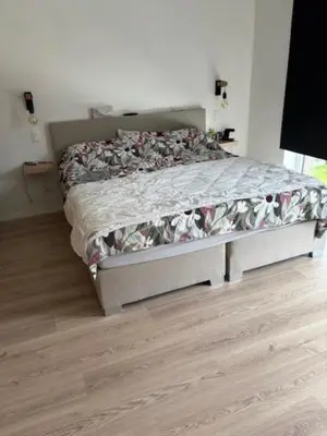 a bedroom with a bed in a room with wood floors at Radja in Boom