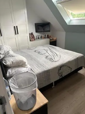 a bedroom with a bed and a trash can at Radja in Boom