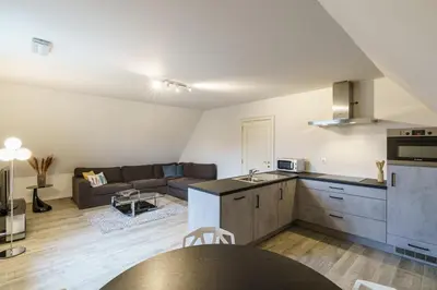 a kitchen and a living room with a couch at Guesthouse De Meelberg in Beringen