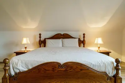 a bedroom with a large wooden bed with two lamps at Guesthouse De Meelberg in Beringen