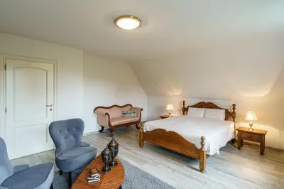 a bedroom with a bed and a chair and a table at Guesthouse De Meelberg in Beringen
