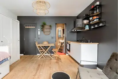 a living room with a table and a kitchen at Charming Private Studio - Nearby Antwerp Central Station in Antwerp