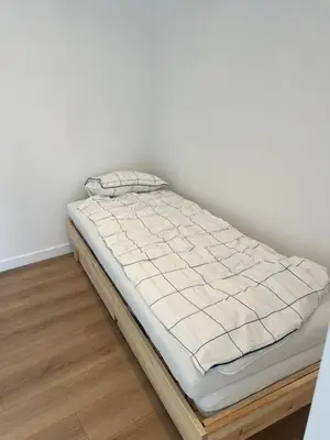 a bed in a room with a white wall at Libre in Temse