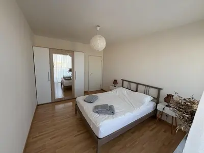 a bedroom with a bed with white sheets on it at Cosy apartment near Zaventem Airport in Brussels