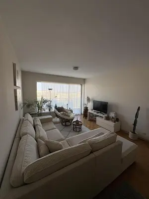 a living room with a large couch and a table at Cosy apartment near Zaventem Airport in Brussels