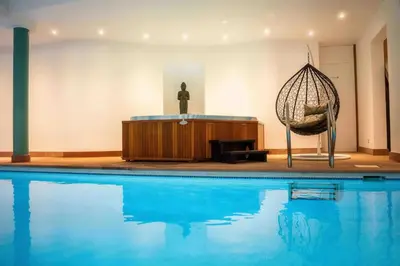 a room with a swimming pool and a swing at Havre de Paix à Bruxelles avec piscine et sauna in Brussels