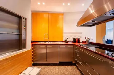 a kitchen with stainless steel cabinets and a sink at Havre de Paix à Bruxelles avec piscine et sauna in Brussels