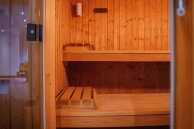 an empty sauna with a wooden wall at Havre de Paix à Bruxelles avec piscine et sauna in Brussels
