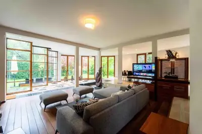 a living room with a couch and a flat screen tv at Havre de Paix à Bruxelles avec piscine et sauna in Brussels