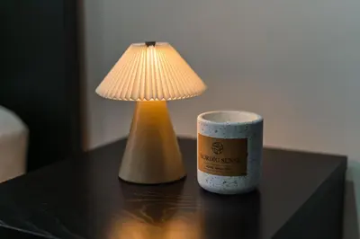 a lamp and a cup on a table with a candle at Elegant 3BR & 1LR Waterfront Retreat in Ghent in Ghent