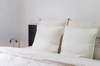a white bed with white pillows on it at Elegant 3BR & 1LR Waterfront Retreat in Ghent in Ghent