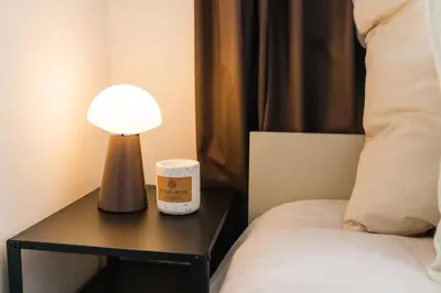 a lamp on a table next to a bed at Elegant 3BR & 1LR Waterfront Retreat in Ghent in Ghent